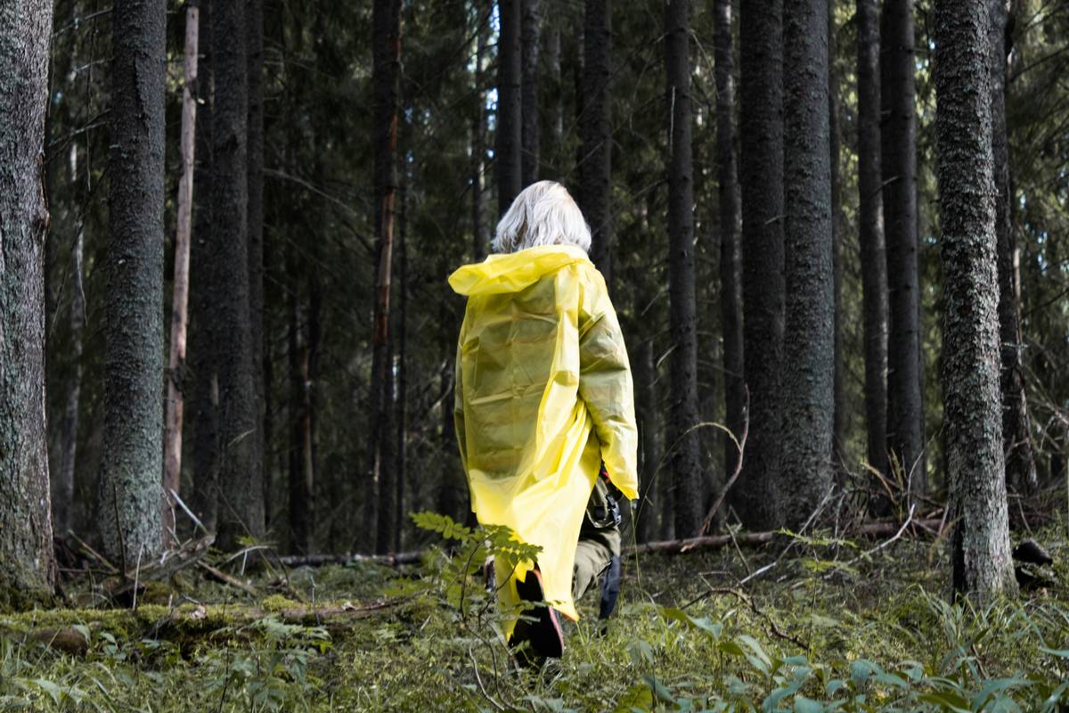Side-by-side comparison of standard poncho vs. storm-resistant travel cape in heavy rain simulation showing water beading on cape vs. soaking through poncho