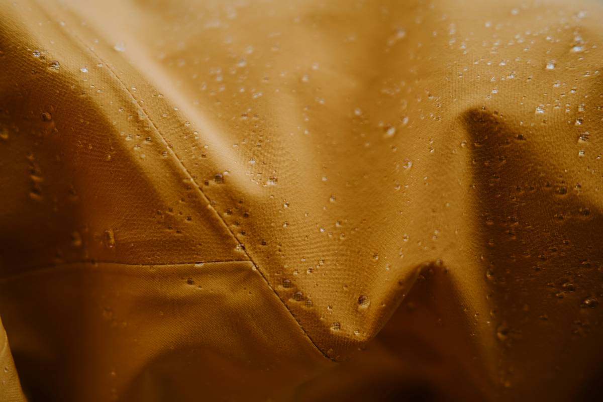 Comparison chart showing thickness, seam sealing, and material durability of five top storm guard poncho covers versus generic rain sleeves