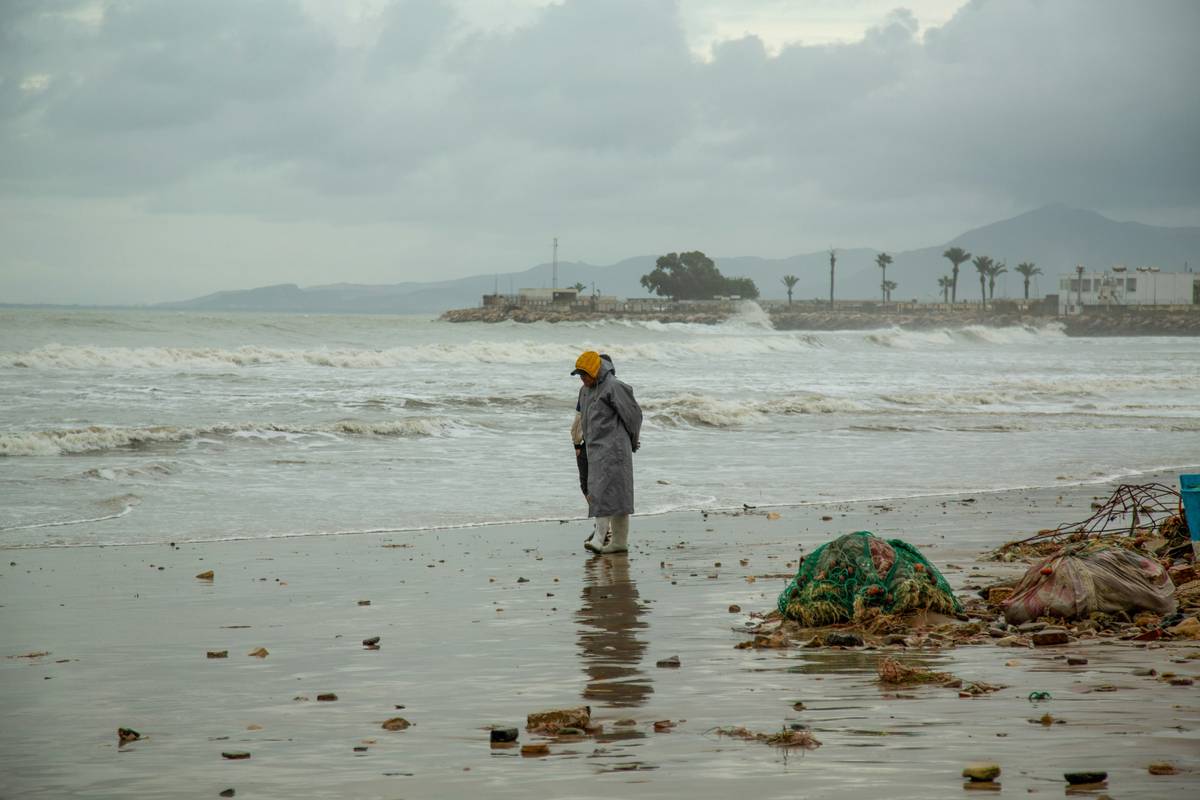 Backpack with storm-protective cover shielding gear during heavy rain
